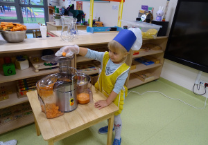09 Dziewczynka wkłada marchewkę do sokowirówki